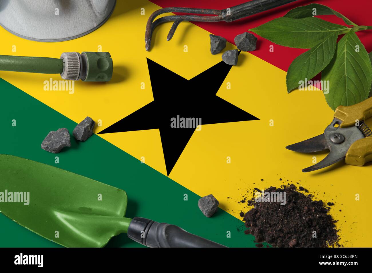 Ghana Flagge mit Gartengeräte Hintergrund auf Tisch. Frühling im Garten Konzept mit kostenlosem Kopierplatz. Stockfoto