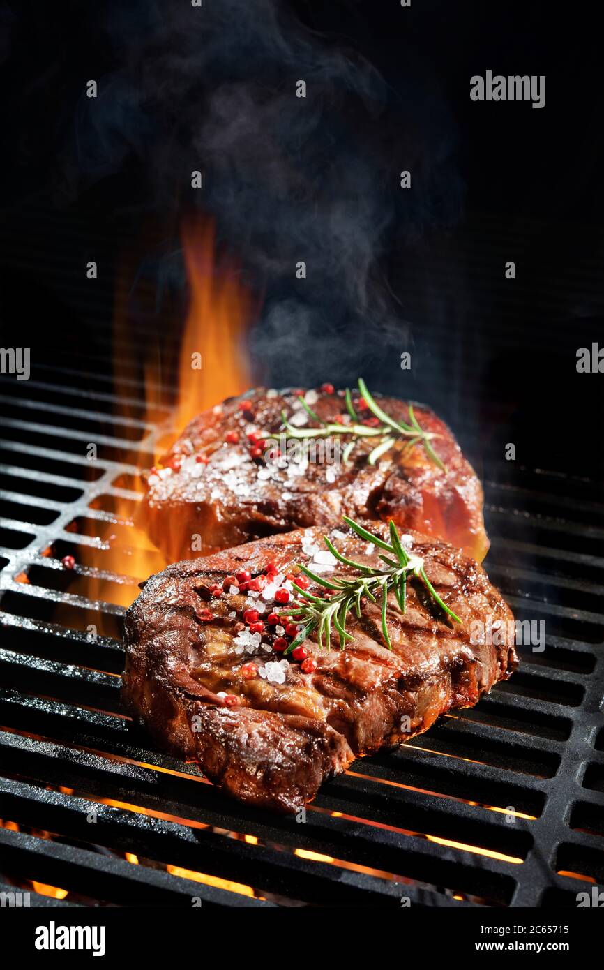 Rindersteaks vom Grill mit Flammen Stockfoto