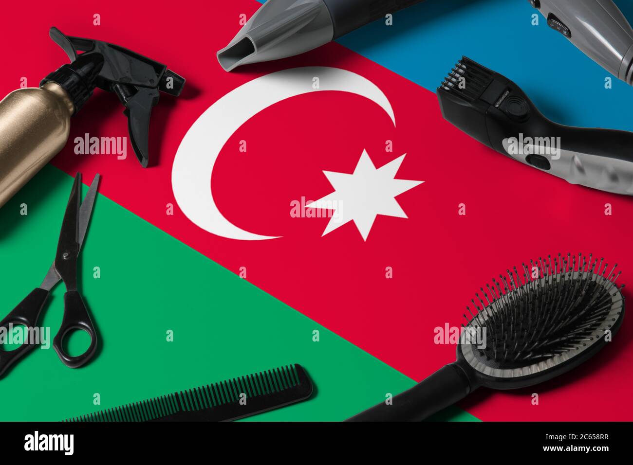 Aserbaidschan Flagge mit Haarschneidemassen. Kämme, Scheren und Friseurwerkzeuge in einem Schönheitssalon Desktop auf einem nationalen Holzhintergrund. Stockfoto