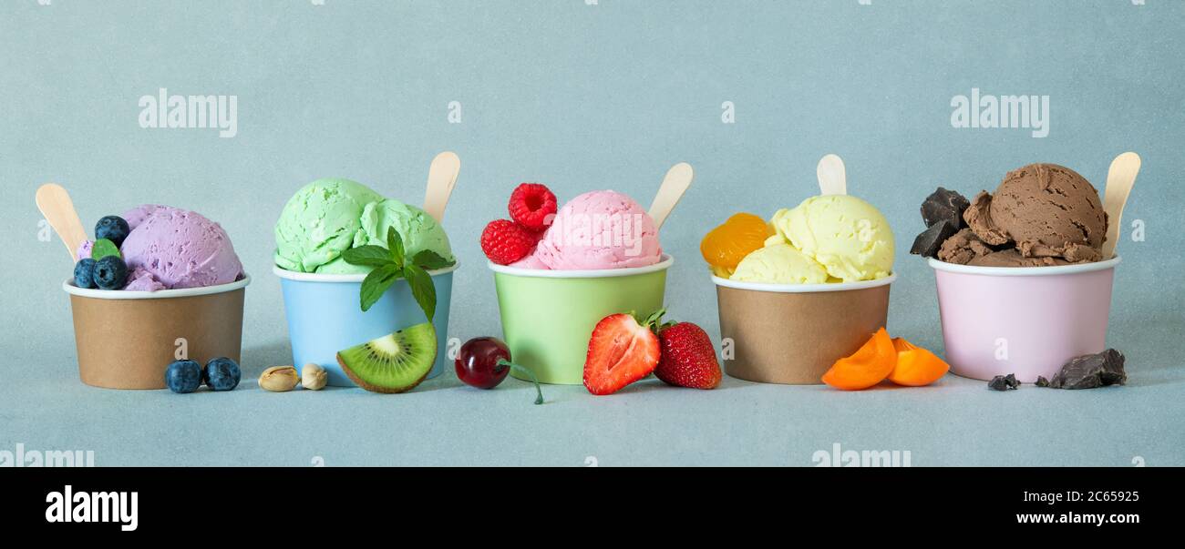 Verschiedene bunte Eiscreme-Sorten mit Früchten in Pappbechern Stockfoto