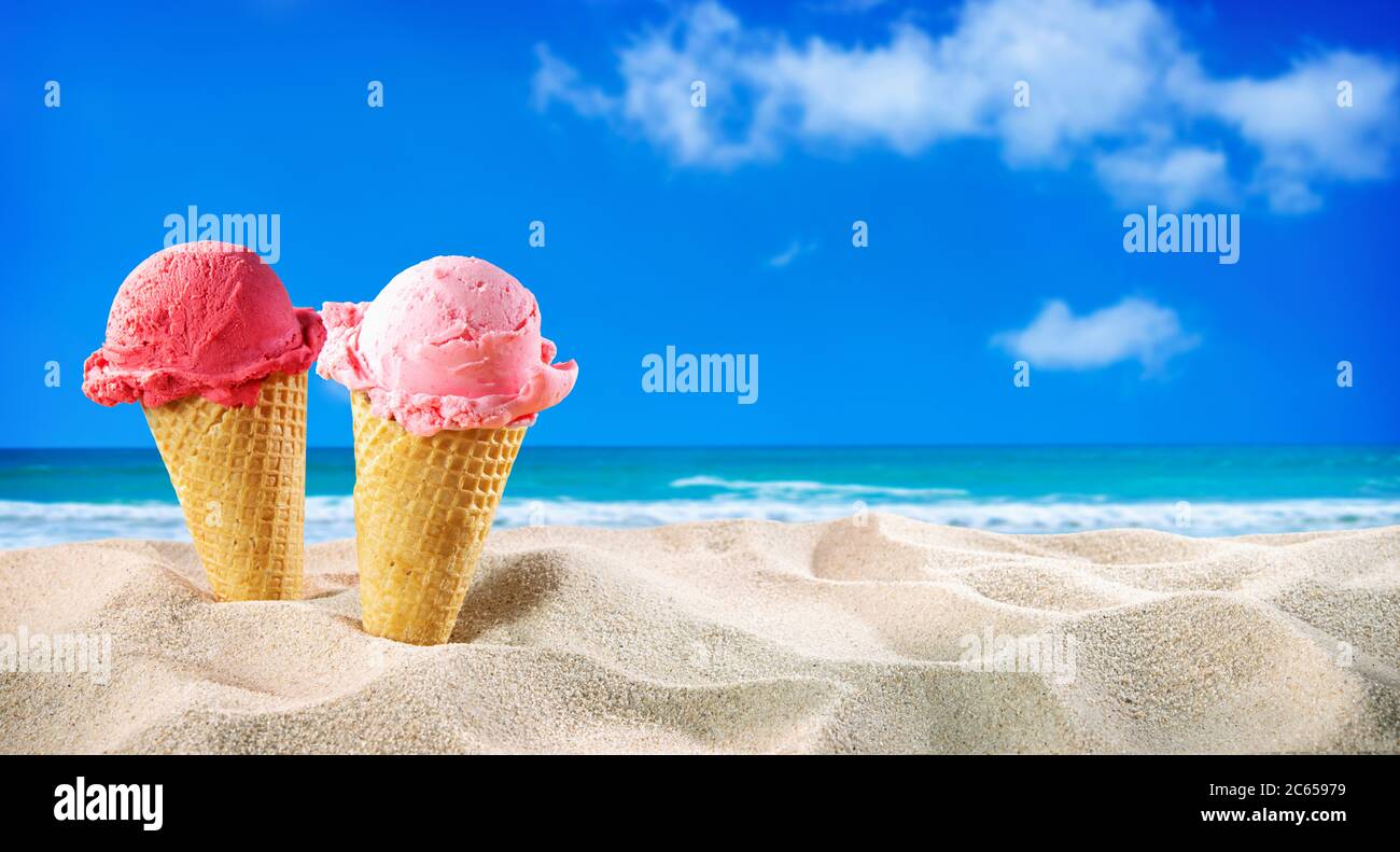 Eiszapfen und Muscheln im Sand am Strand mit Meereslandschaft Stockfoto