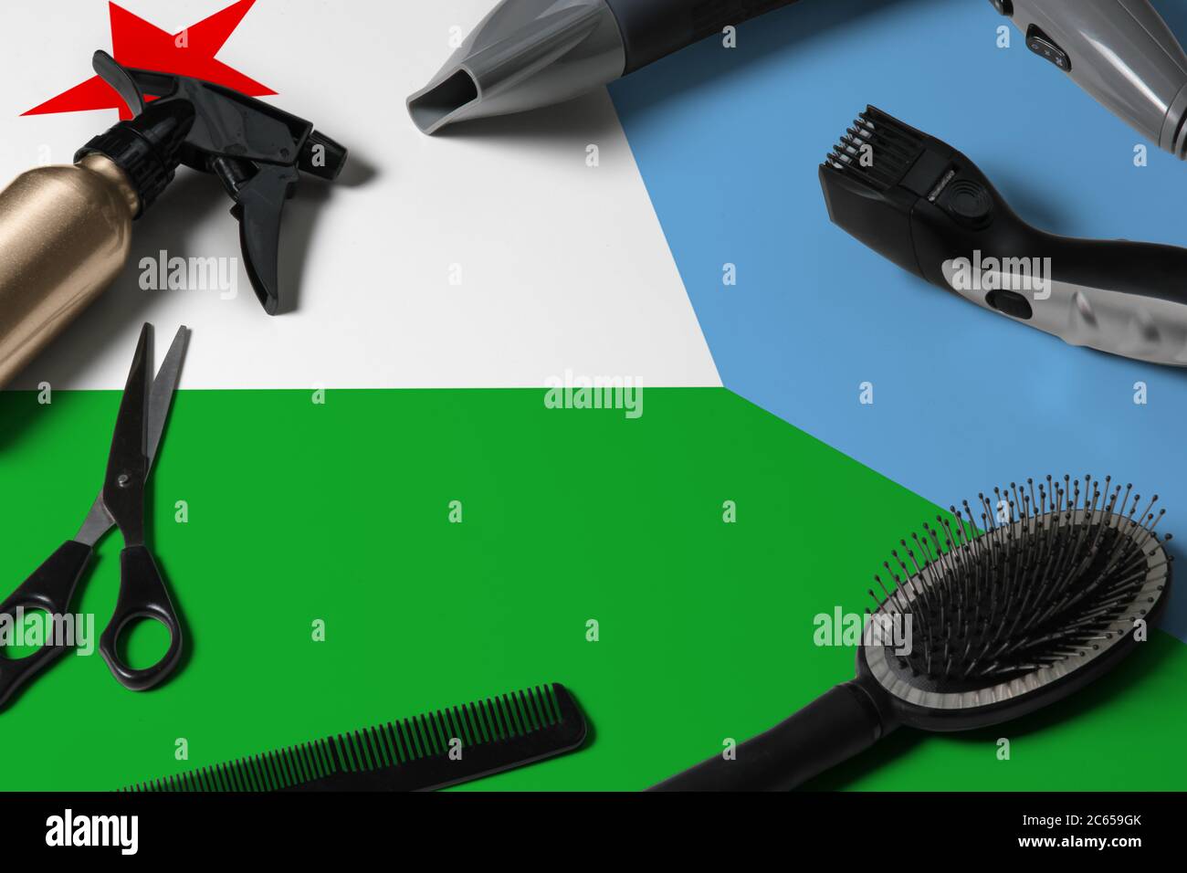 Dschibuti Flagge mit Haarschneidemasten. Kämme, Scheren und Friseurwerkzeuge in einem Schönheitssalon Desktop auf einem nationalen Holzhintergrund. Stockfoto
