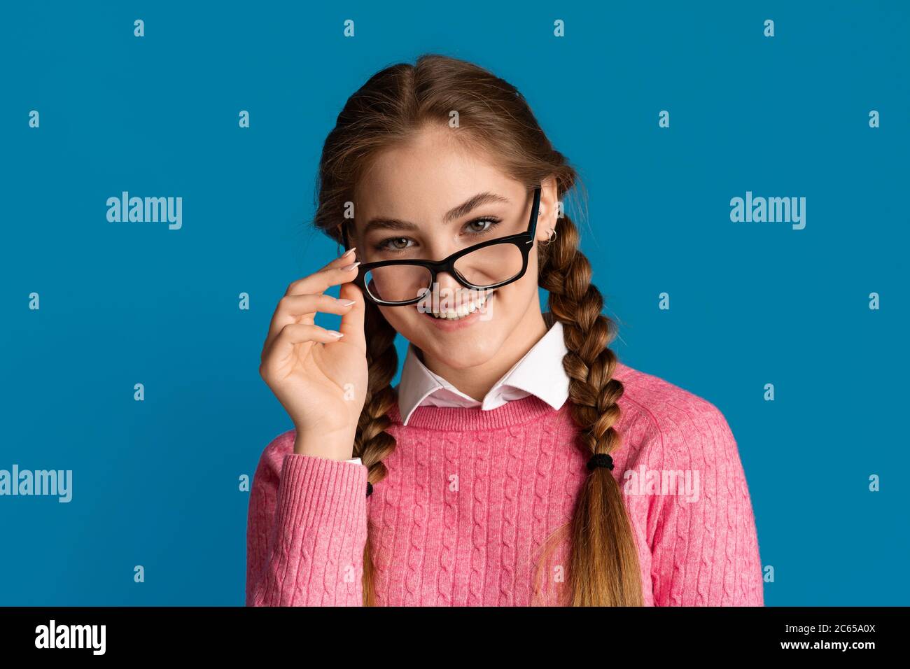 Gute Laune in der Schule.. Lächelndes Teenager Mädchen nimmt Brille ab. Stockfoto