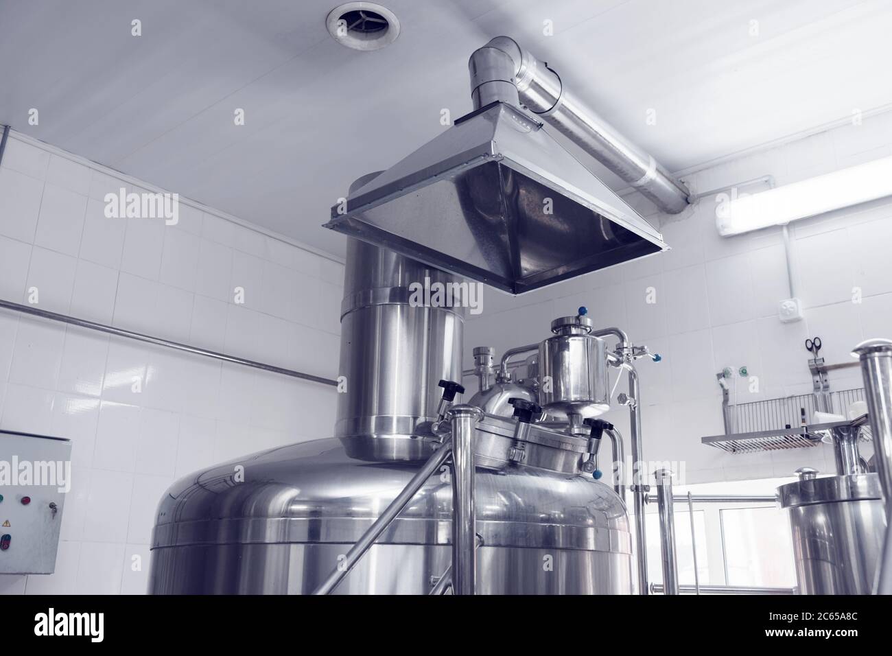 Belüftungssystem in einer Brauerei - Absaughaube über Bierbrautanks, getönt Stockfoto