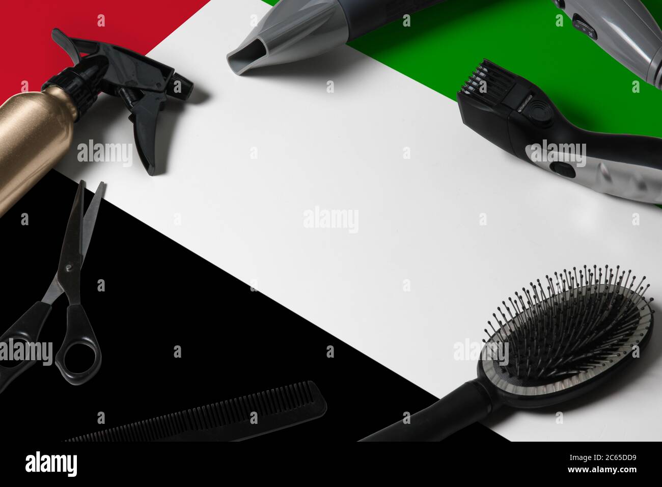 Vereinigte Arabische Emirate Flagge mit Haarschneidemassen. Kämme, Scheren und Friseurwerkzeuge in einem Schönheitssalon Desktop auf einem nationalen Holzhintergrund. Stockfoto