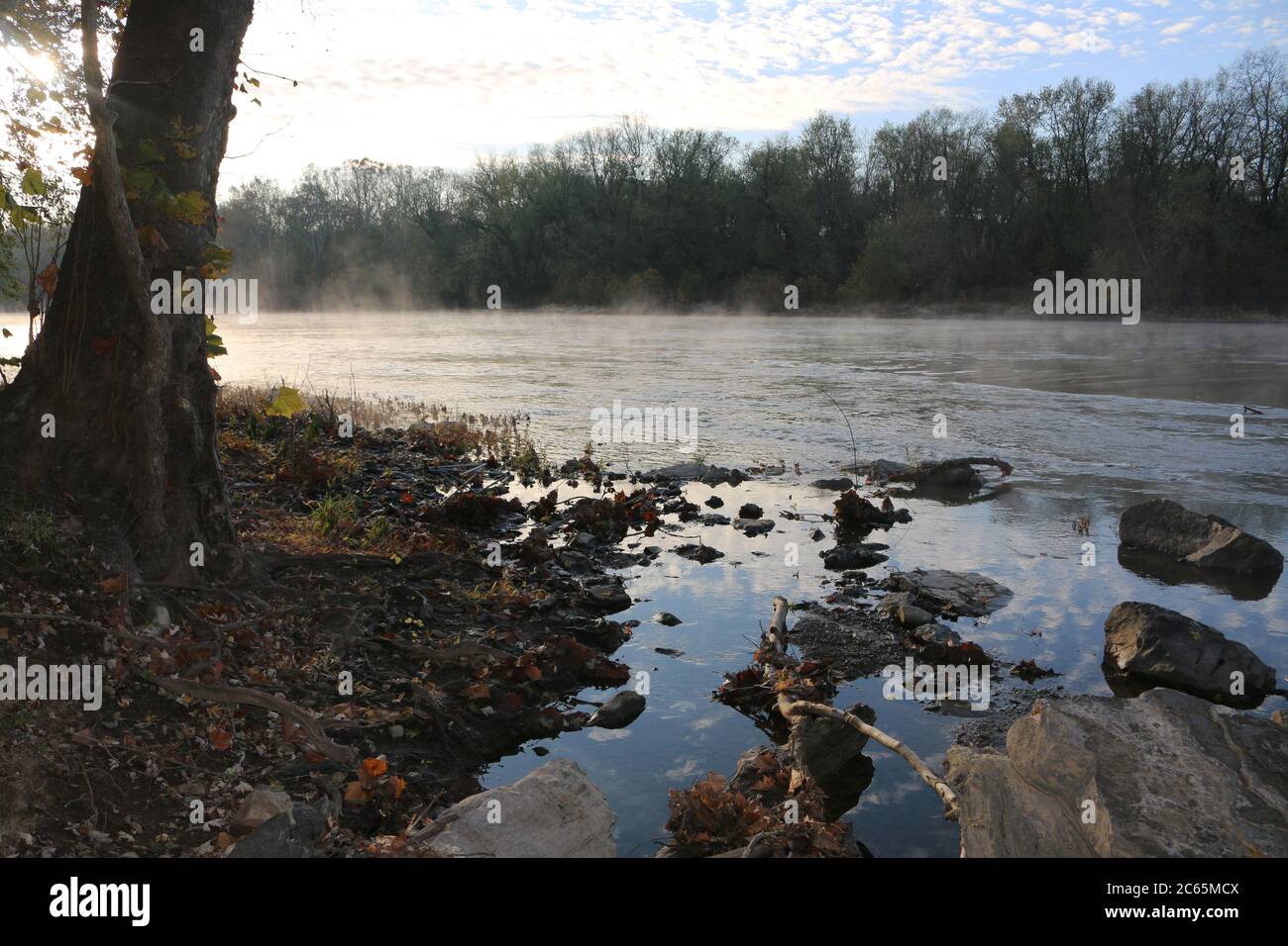 Morgennachmittag Reflexion über einen nebligen Fluss mit Felsen Stockfoto