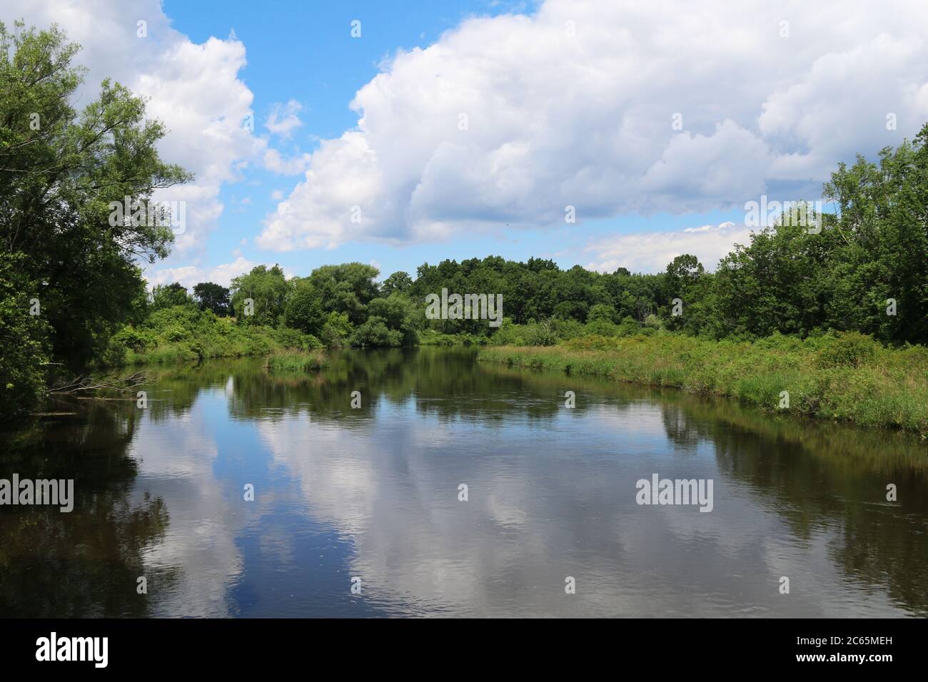 Ein ruhiger Blick auf den See mit weißen Wolken und blauen Himmel Reflexion Stockfoto