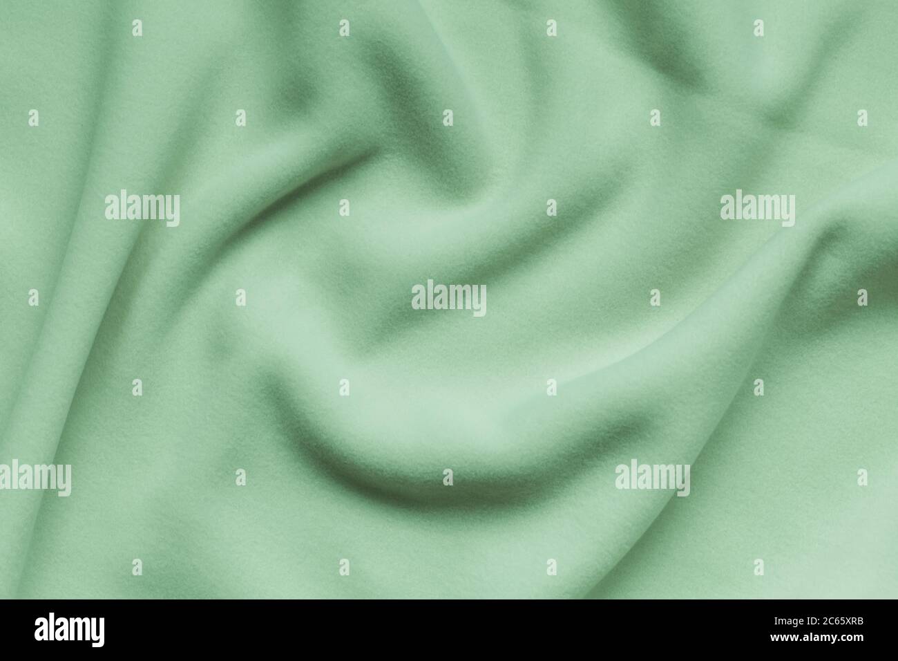 Hellgrünes Fleece-Hintergrundtextur, weiches, genapptes Isoliermaterial aus Polyester, abstraktes Wellenmuster, Draufsicht Stockfoto