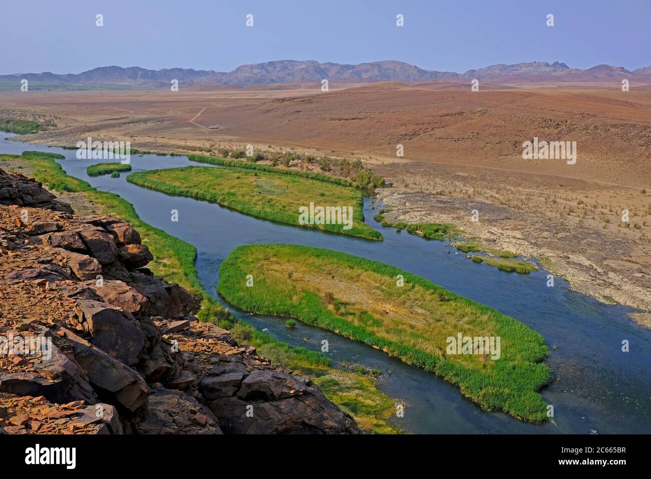 Blick von einem Felsen auf das reedy Flussbett des Grenzflusses Oranje zwischen Namibia und Südafrika. Stockfoto