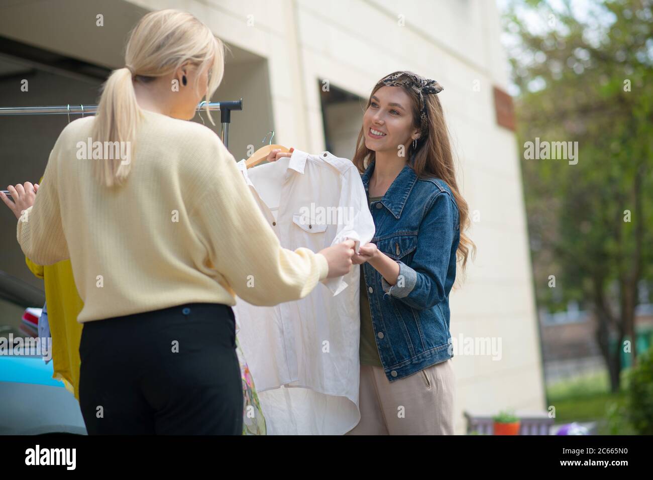 Positive nette Frau bietet die Bluse an den Kunden Stockfoto
