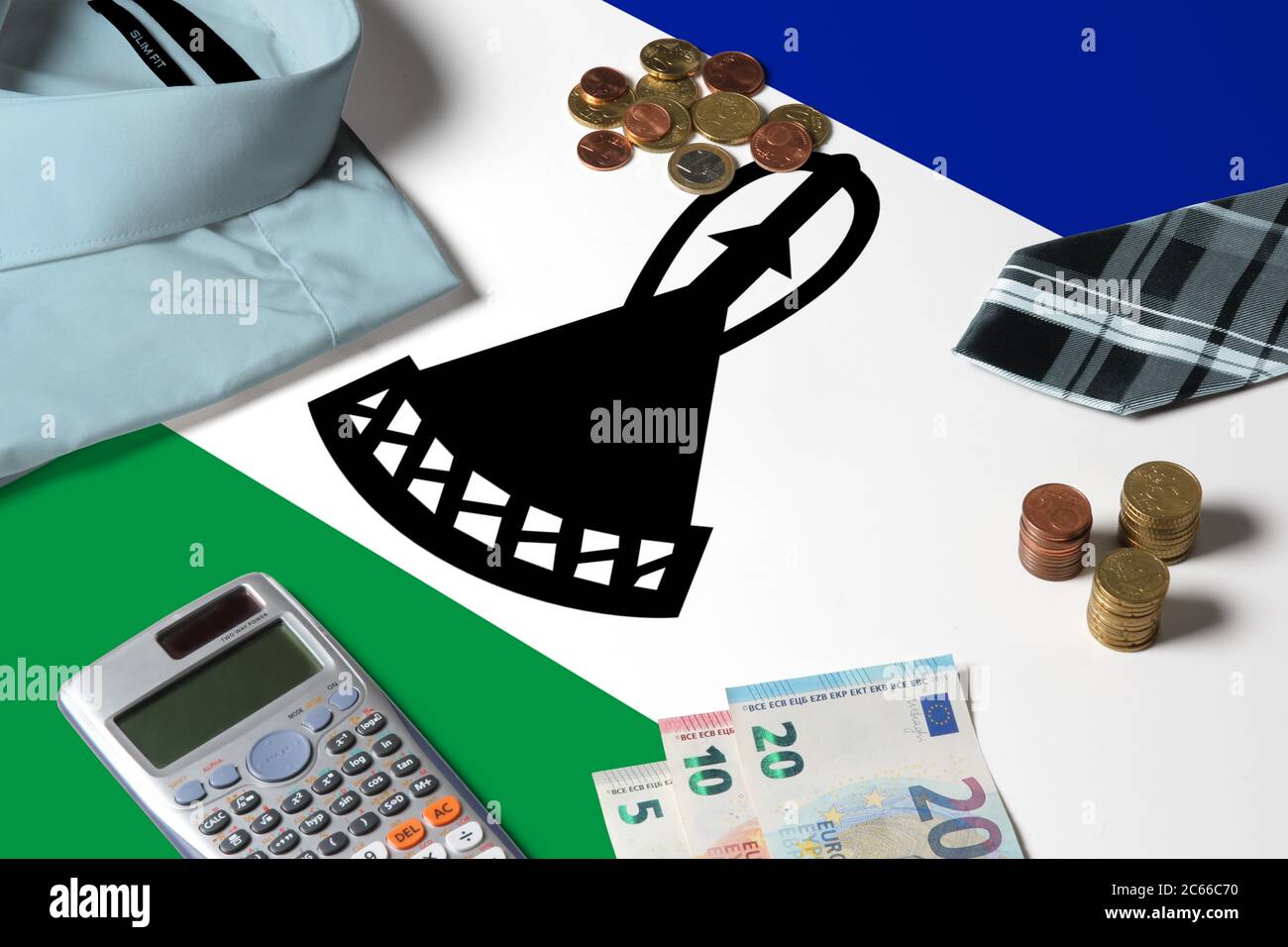 Lesotho Flagge auf Minimal Money Concept Table. Münzen und Finanzobjekte auf Flaggenoberfläche. Thema der Volkswirtschaft. Stockfoto