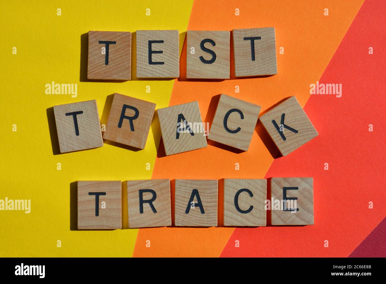 Test, Track, Trace, Wörter in Holzbuchstaben auf buntem Hintergrund isoliert Stockfoto