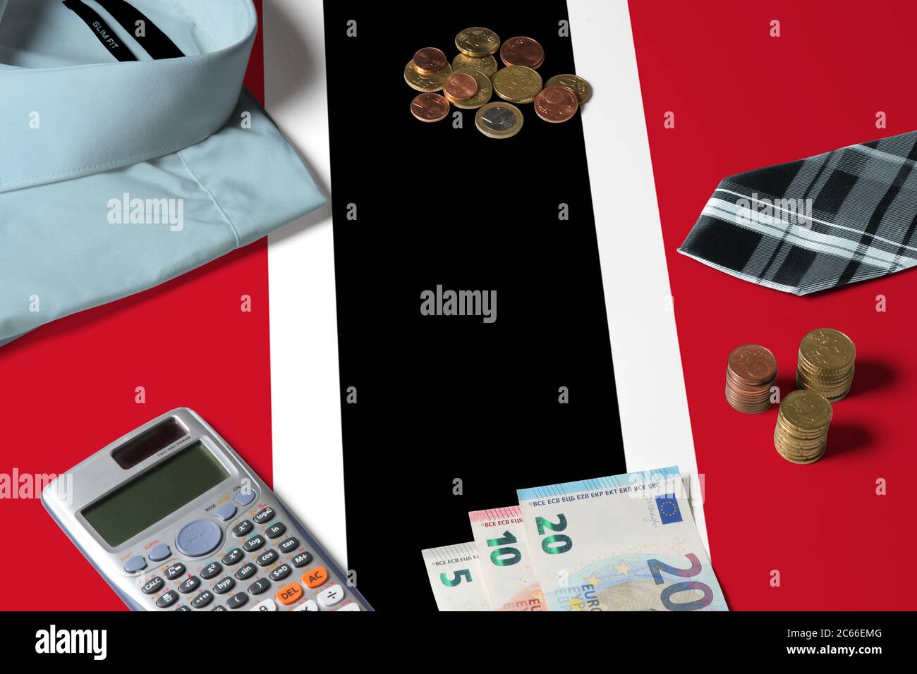 Trinidad und Tobago Flagge auf Minimal Money Concept Table. Münzen und Finanzobjekte auf Flaggenoberfläche. Thema der Volkswirtschaft. Stockfoto