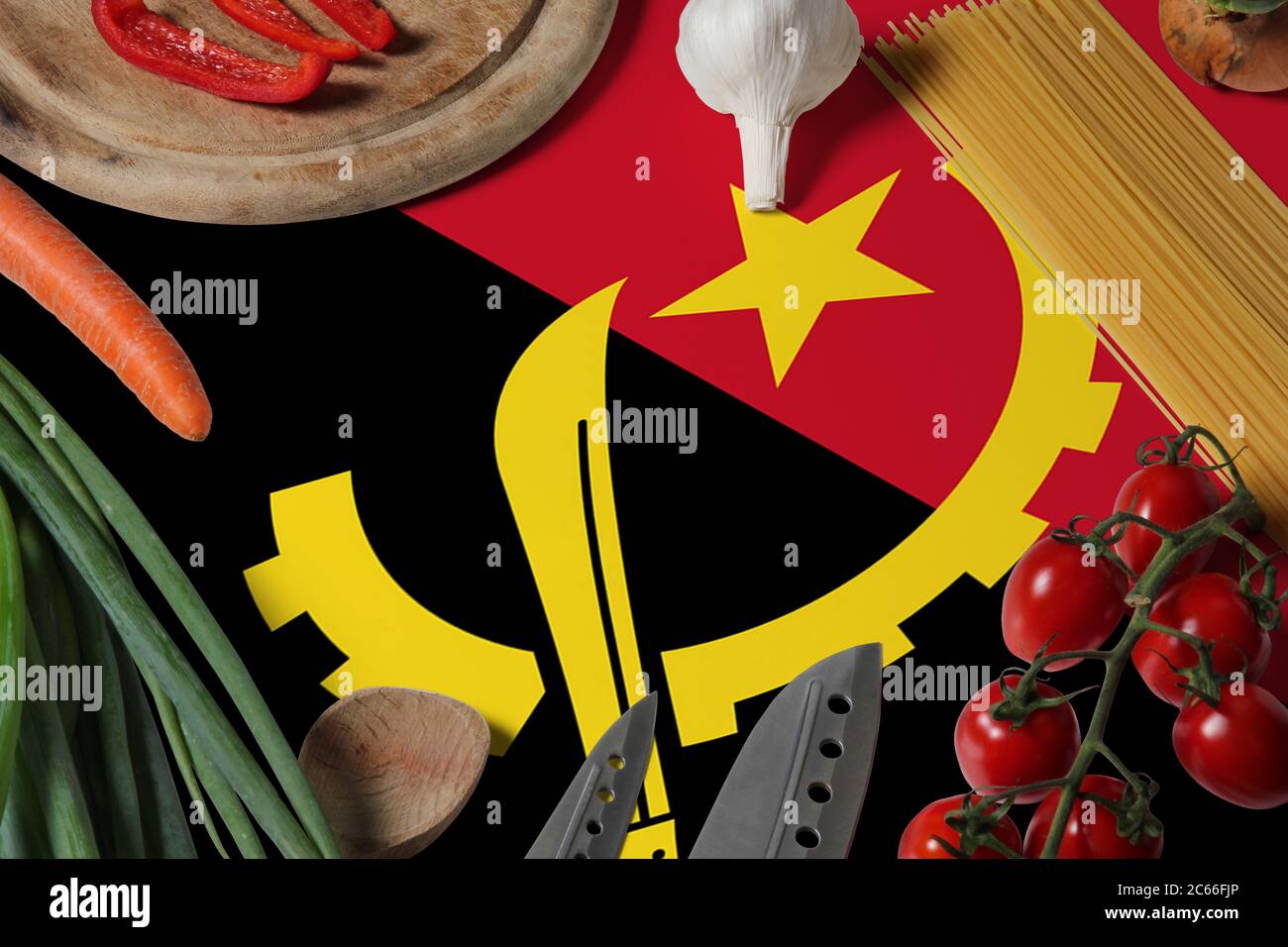 Angola-Flagge auf frischem Gemüse und Messer Konzept Holztisch. Kochkonzept mit Vorbereitung Hintergrundthema. Stockfoto