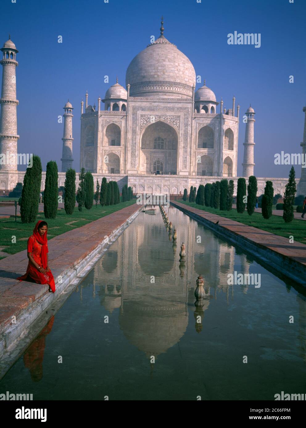 Indien, Agra, Taj Mahal, Lady in Red Sari Blick in Pool mit dem Majastic Taj Mahal im Hintergrund. Stockfoto