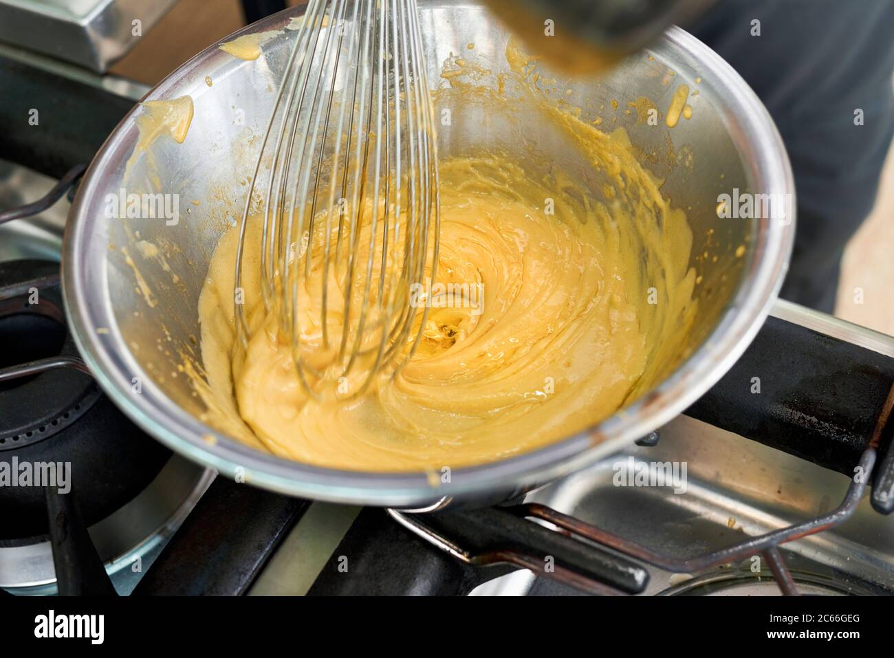Zubereitung von Béarnaise Sauce Schritt für Schritt, geklärt Butter wird sanft auf den Sabayon hinzugefügt Stockfoto