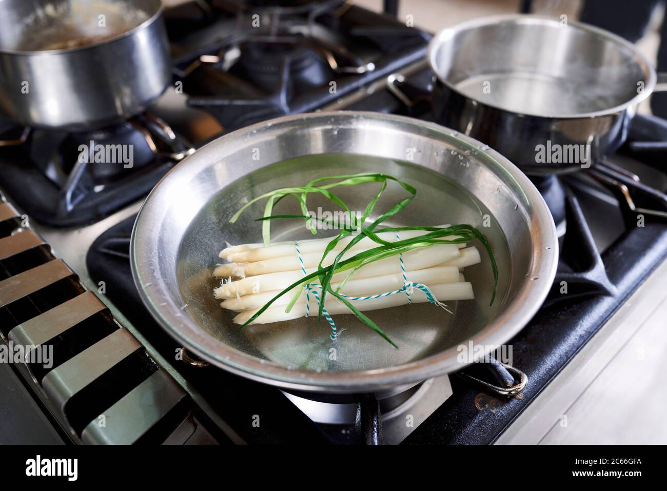 Zubereitung von Spargel mit Béarnaise Sauce Schritt für Schritt, gebündelte Spargelspieße in heißem Wasser Stockfoto