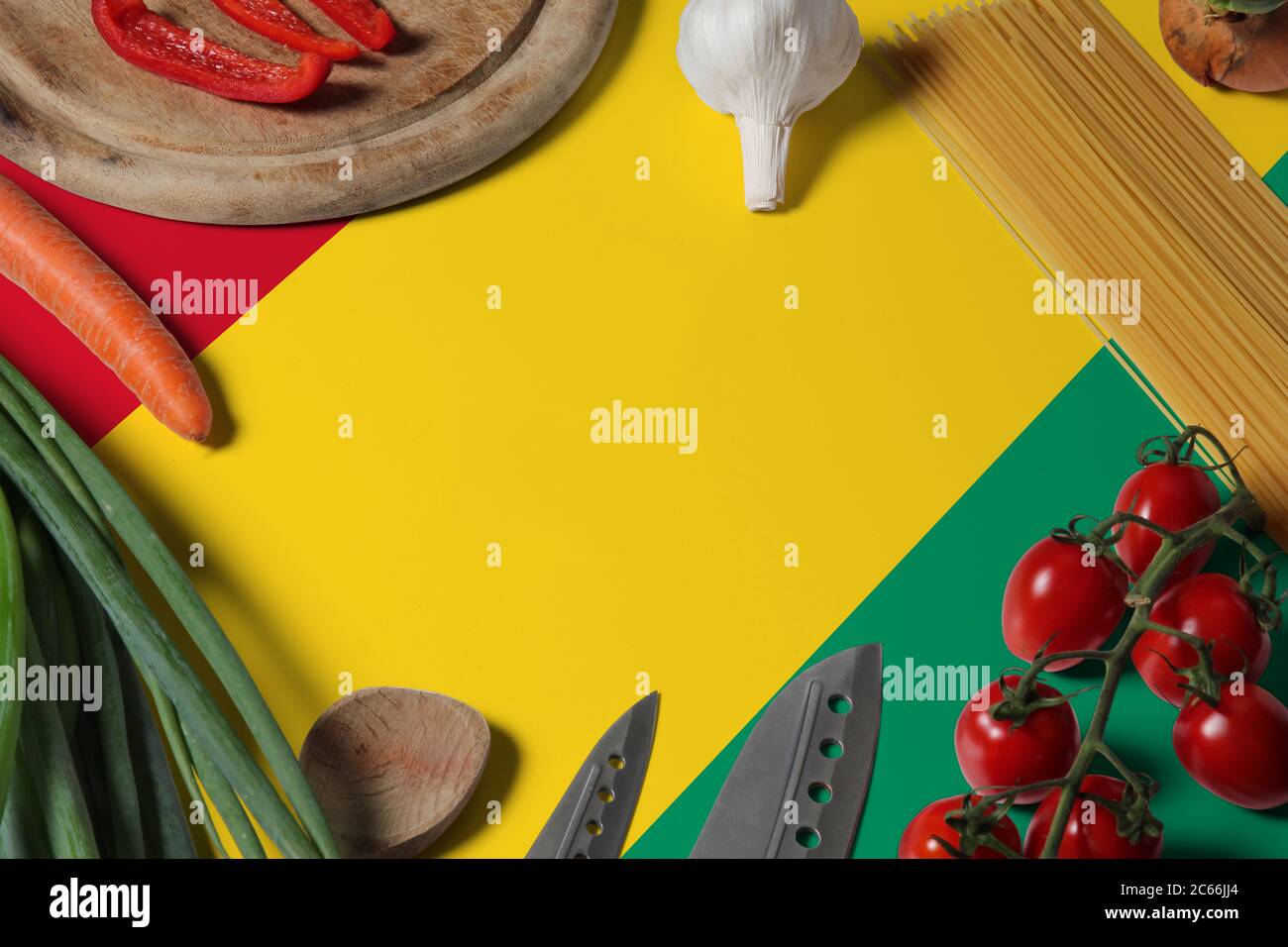 Guinea Bissau Flagge auf frischem Gemüse und Messer Konzept Holztisch. Kochkonzept mit Vorbereitung Hintergrundthema. Stockfoto