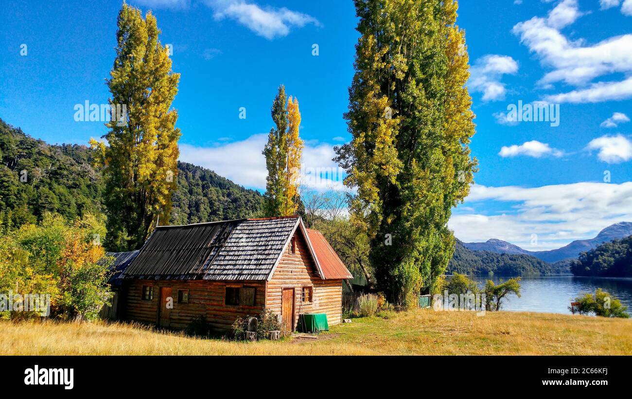 Holzhaus unter großen Bäumen am See Espejo Chico, Argentinien Stockfoto