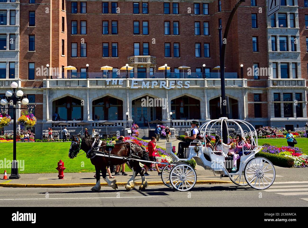 Eine Kutsche, die vor dem berühmten Empress Hotel am Wasser in Victoria British Columbia, Kanada, fährt. Stockfoto