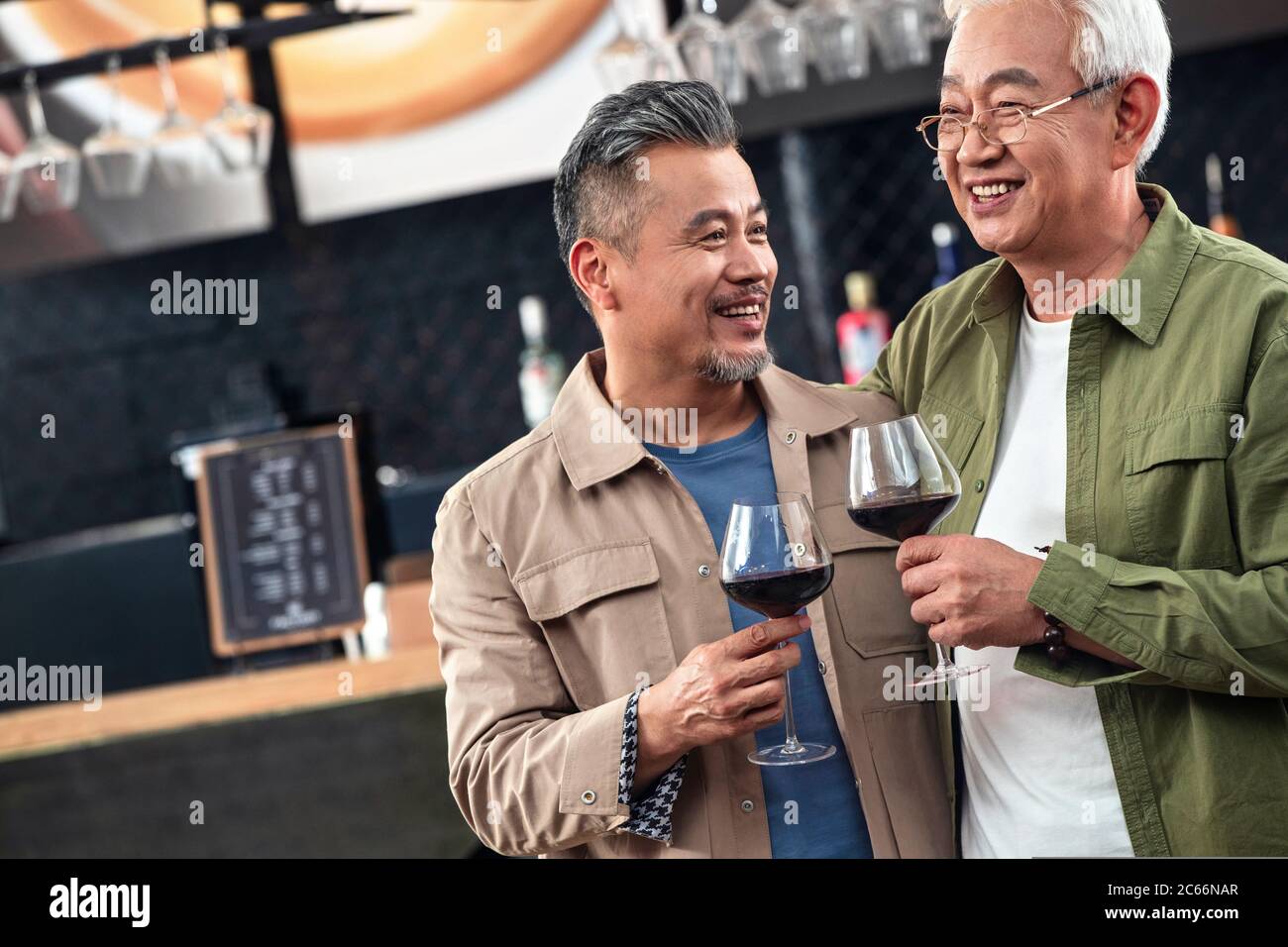 Glückliche alte Brüder, Rotwein zu toasten nehmen Stockfoto