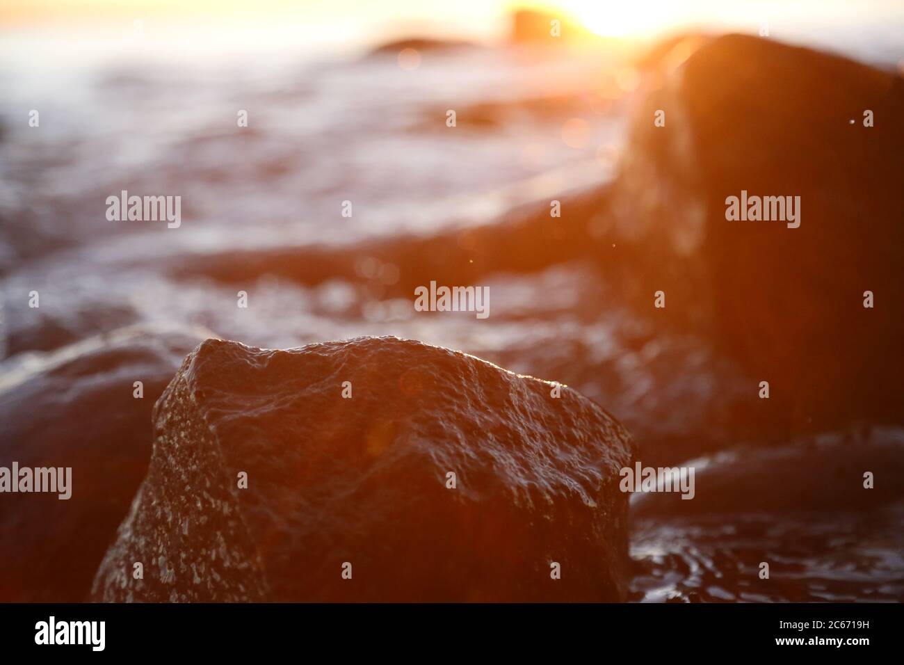 Steinige Strandsteine und Felsen, die abends in der Nähe beleuchtet sind, Sonnenuntergang und Sonnenaufgang Stockfoto