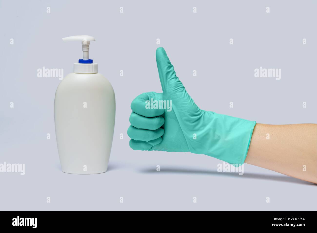 Weibliche Hand in Latex-Gummihandschuh und Hand Desinfektionsmittel oder Flüssigseife Spender über hellgrauem Hintergrund Stockfoto