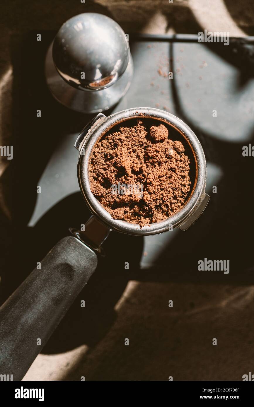 Gemahlener Kaffee in einem Portafilter und einer Kaffeepulver. Stockfoto