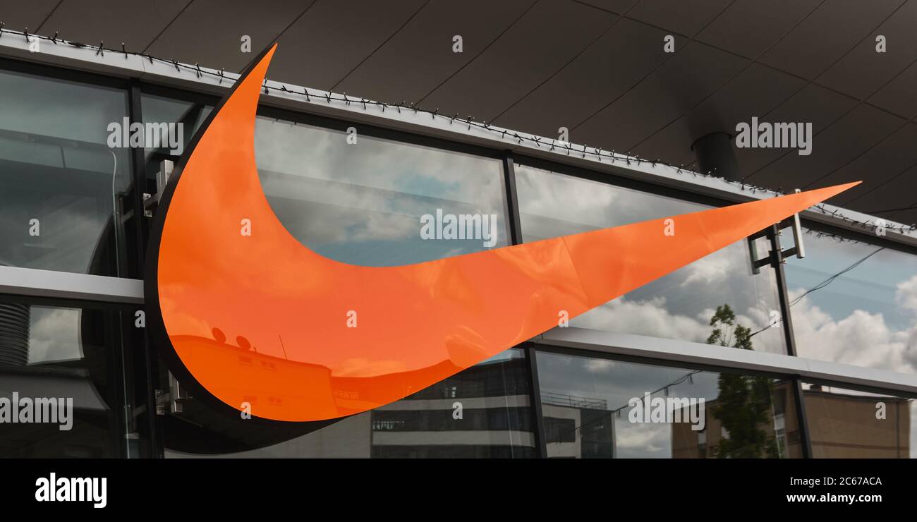 Berlin, Deutschland, 6. Mai 2020: Orangefarbenes Nike Logo an einer Wand in einem offiziellen Nike Store Stockfoto