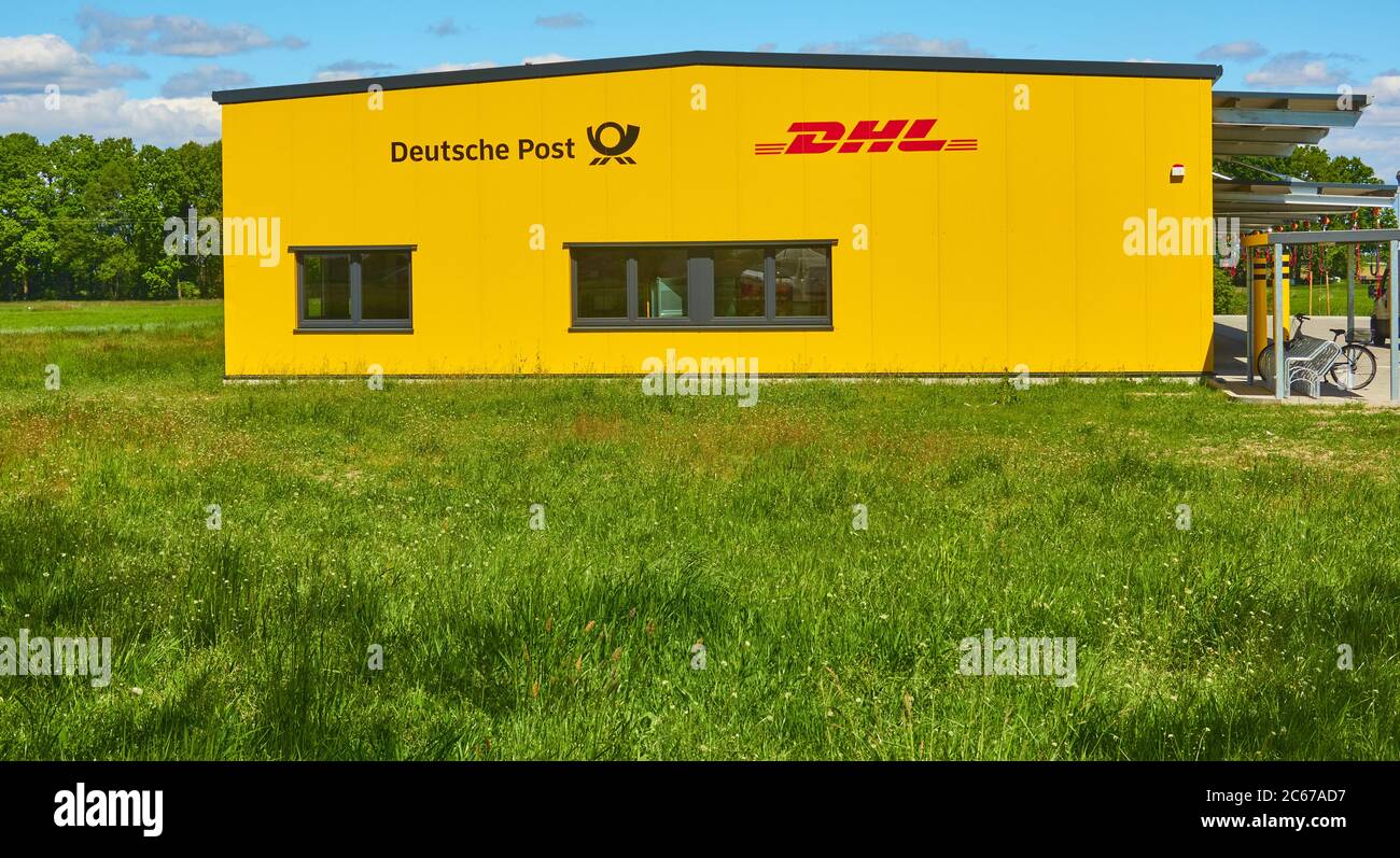 Gifhorn, 15. Mai 2020: Hellgelbes Standortgebäude eines deutschen Logistikunternehmens hinter einem grünen Feld, Post, Paketverteiler Stockfoto