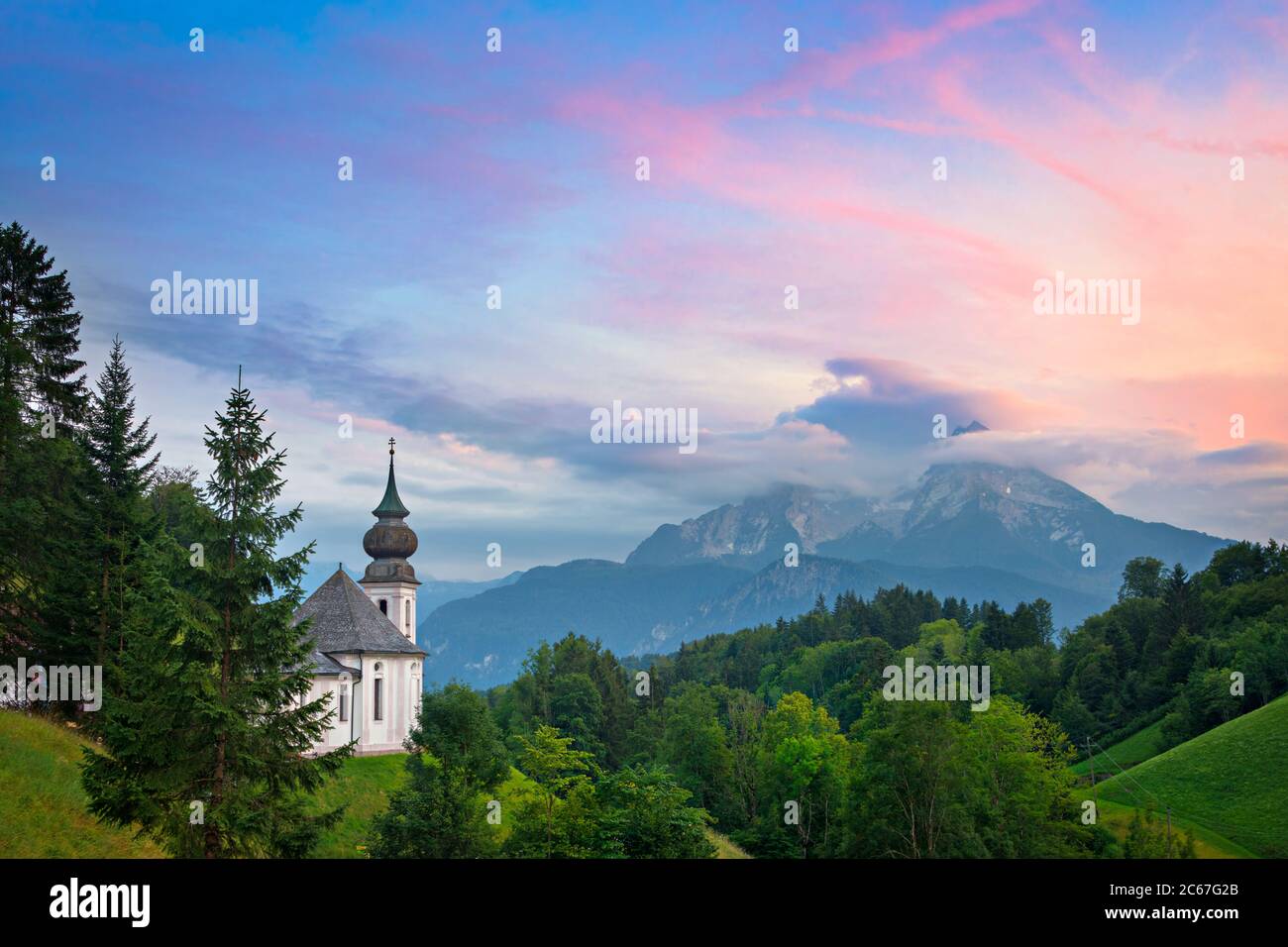 Die Kirche Maria Gern mit Blick auf den Watzmann in den Alpen bei einem bunten Sonnenuntergang an einem Sommerabend in Berchtesgaden, Bayern, Deutschland. Stockfoto