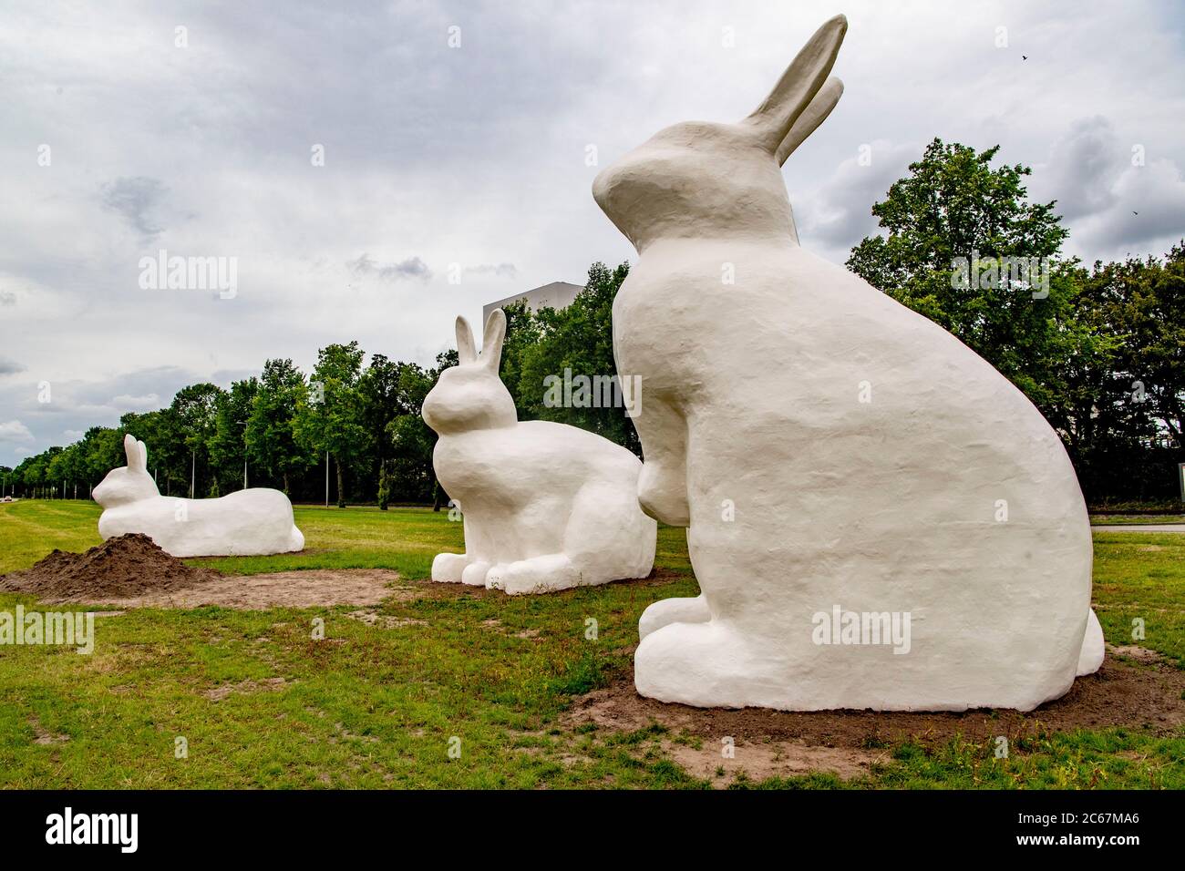 Drei riesige Kaninchenstatuen (Berm Bunnies) bilden einen Blickfang auf der Schnellfahrradroute von Amsterdam nach Zaanstad im Hafengebiet von Amsterdam. Stockfoto