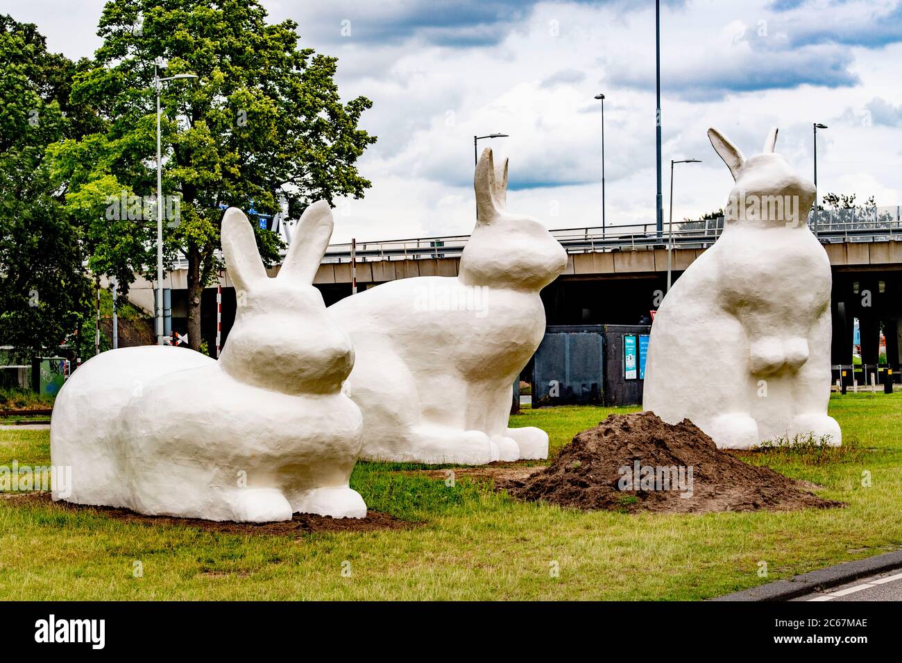 Drei riesige Kaninchenstatuen (Berm Bunnies) bilden einen Blickfang auf der Schnellfahrradroute von Amsterdam nach Zaanstad im Hafengebiet von Amsterdam. Stockfoto