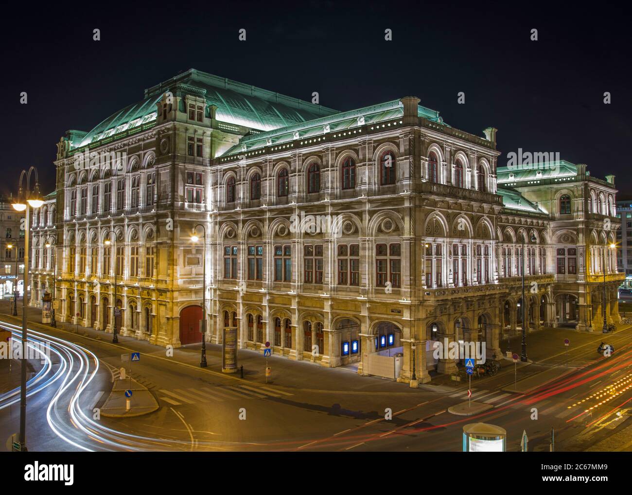 Nachtaufnahme der Wiener Oper mit verschwommener Ampel Stockfoto