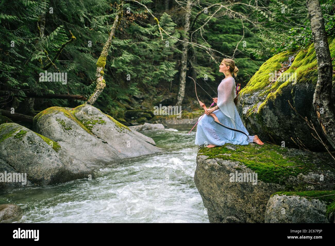 Frau mit Bogen inmitten eines malerischen Waldes, Deception Falls National Recreation Area, Washington, USA Stockfoto