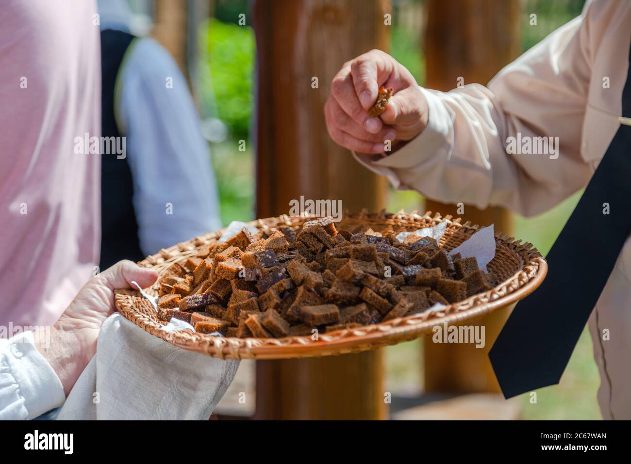 Nahaufnahme der Hand nehmen hausgemachte Roggenbrot Probe im Freien Festival. Bio-Schwarzbrot Stockfoto