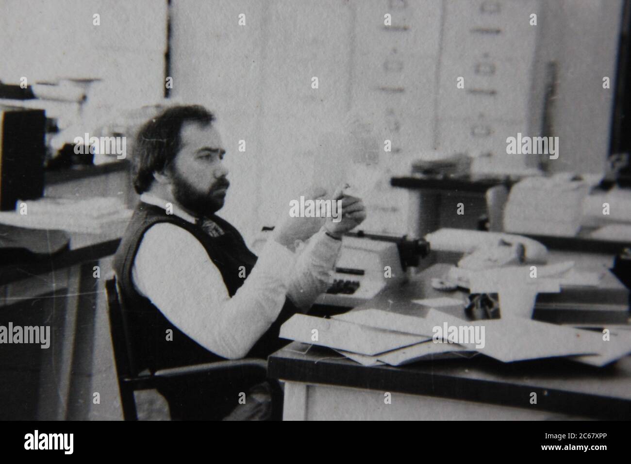 Feine 70er Jahre Vintage schwarz-weiß Lifestyle Fotografie eines Büroangestellten arbeitet einen Schreibtisch Job. Stockfoto