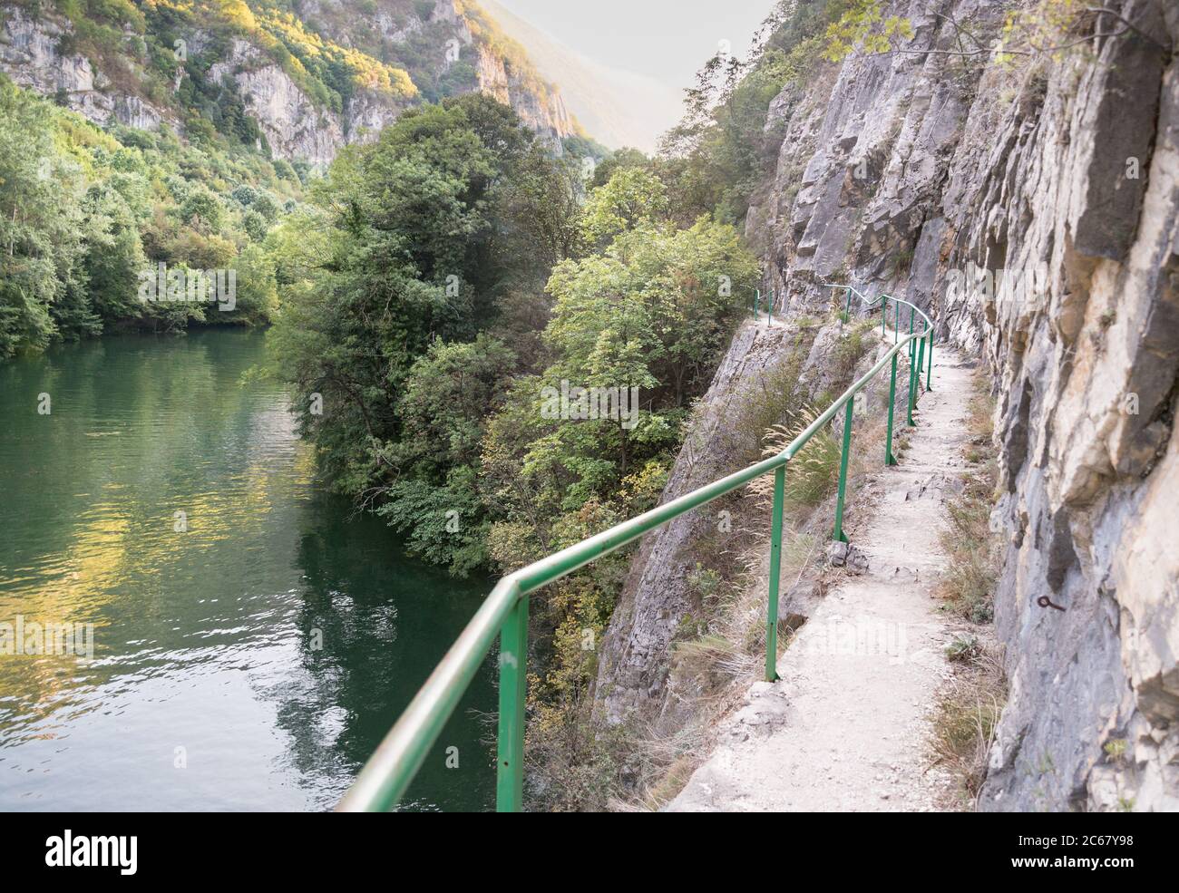 Besucher können den Weg neben dem Fluss Treska entlang der steilen felsigen Berghänge und ruhigen Gewässern des Matka-Sees zu Fuß. Stockfoto