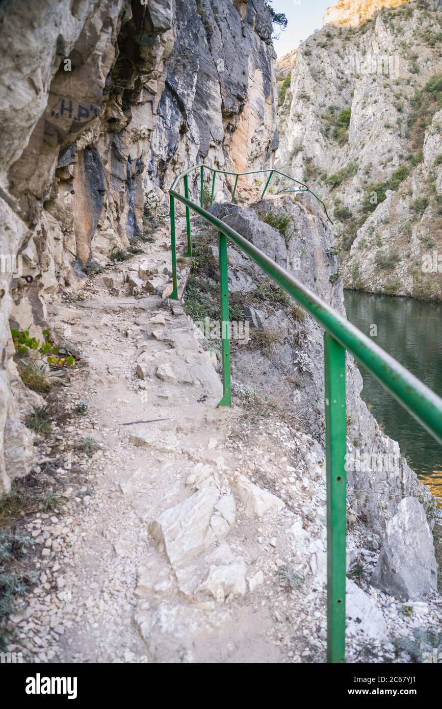 Besucher können den Weg neben dem Fluss Treska entlang der steilen felsigen Berghänge und ruhigen Gewässern des Matka-Sees zu Fuß. Stockfoto
