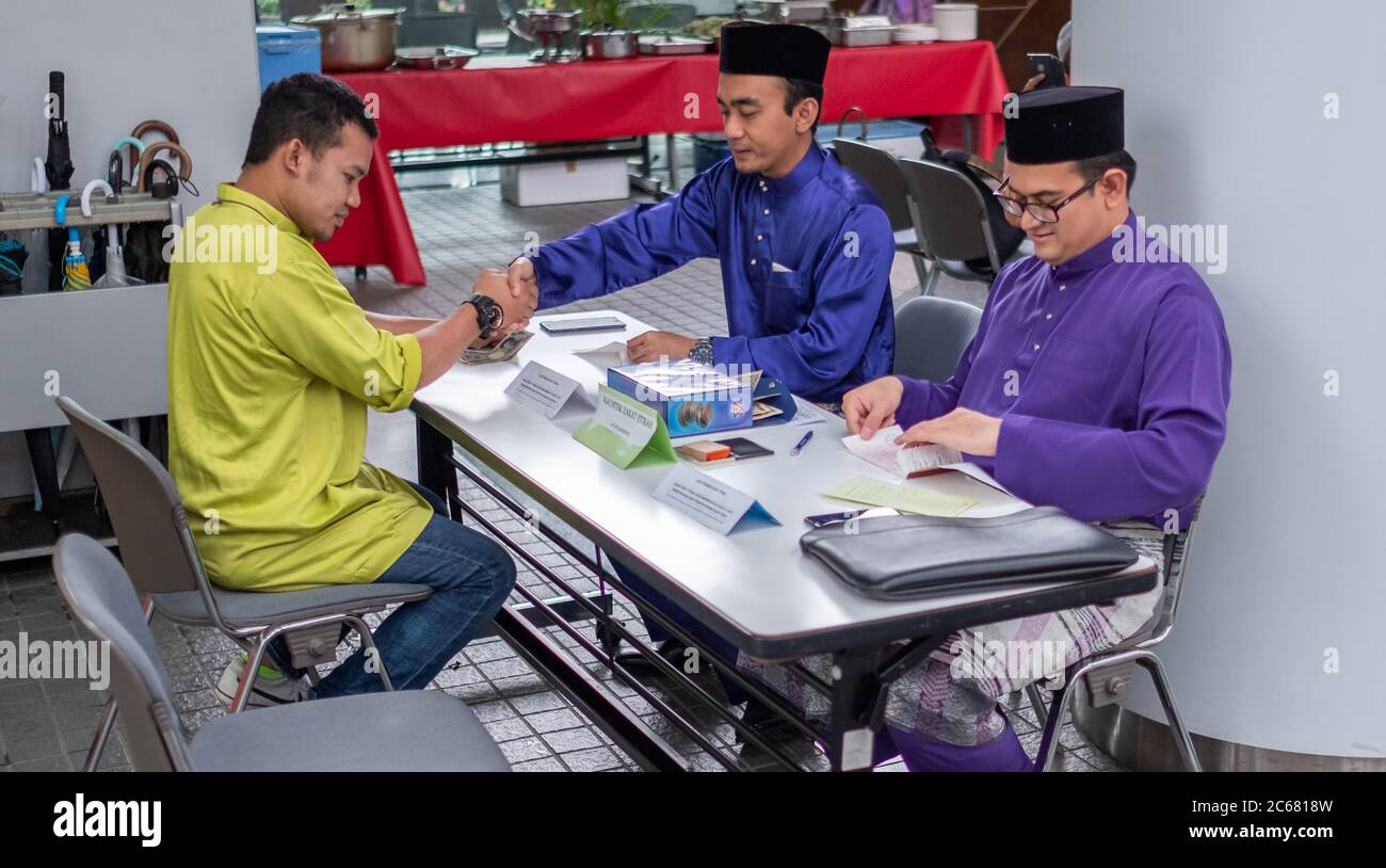 Muslim, der das obligatorische Zakat (Almosengeben) während der Eid-Feier, Tokio, Japan, bezahlt Stockfoto