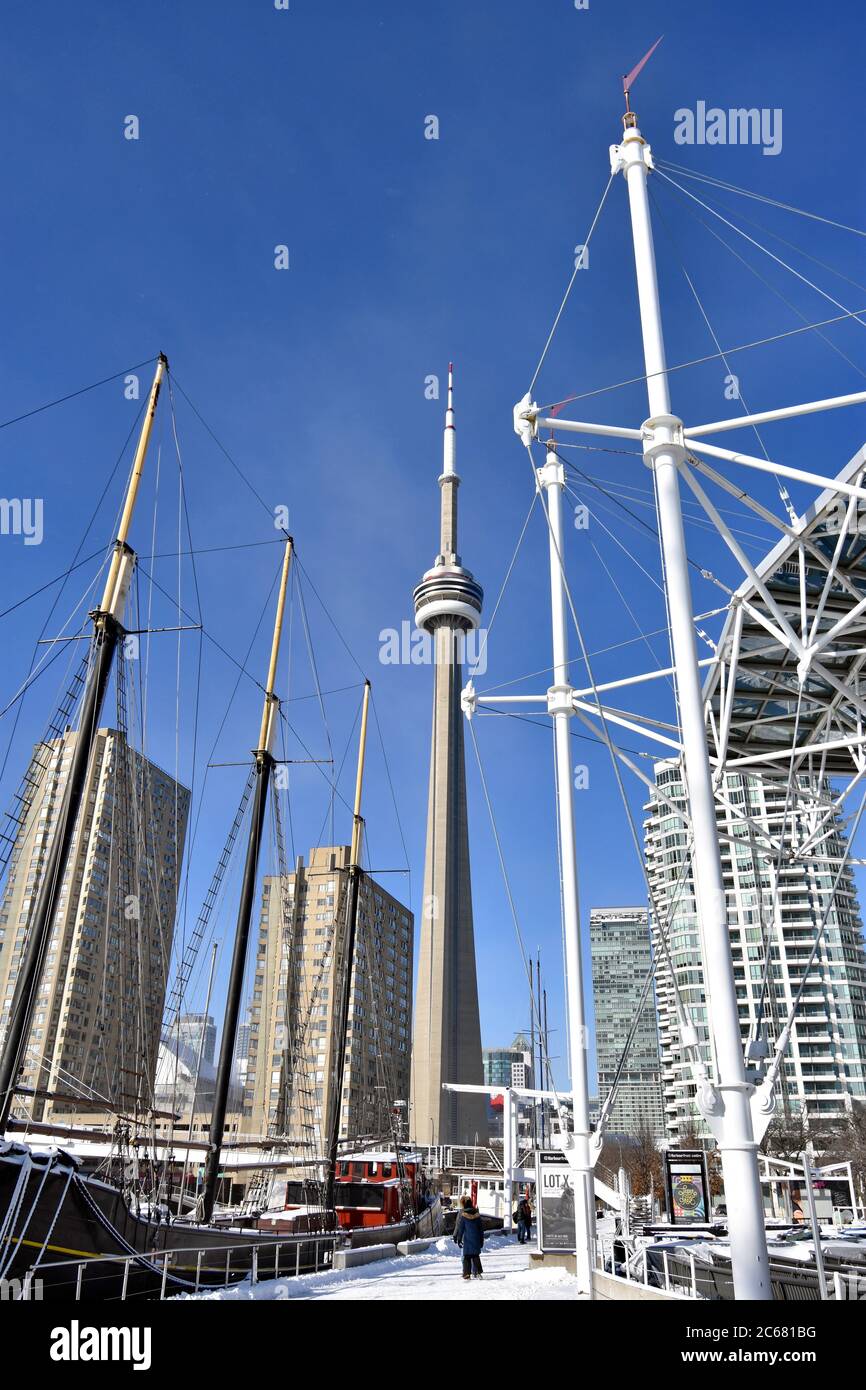 Schiffe Segel kann man an einem klaren Tag im Hafen Front Center in Toronto sehen. Der CN Tower und andere hohe Gebäude sind gegen den blauen Himmel zu sehen. Stockfoto