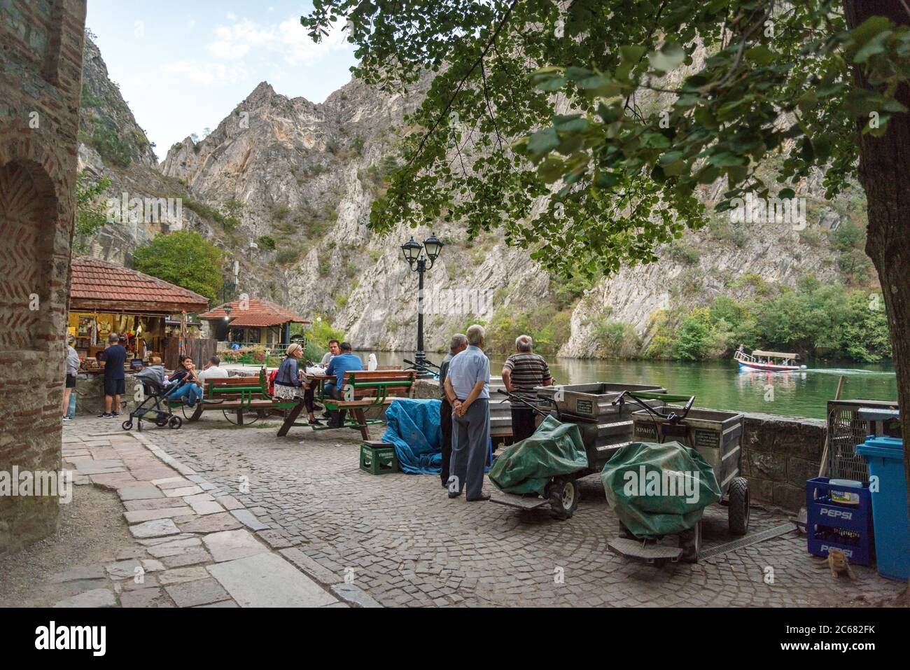 Am Matka Canyon, in der Nähe von Skopje, beginnen sich die Menschen am frühen Abend zu einem Essen oder Getränk neben dem ruhigen Wasser des Matka Sees zu versammeln. Stockfoto
