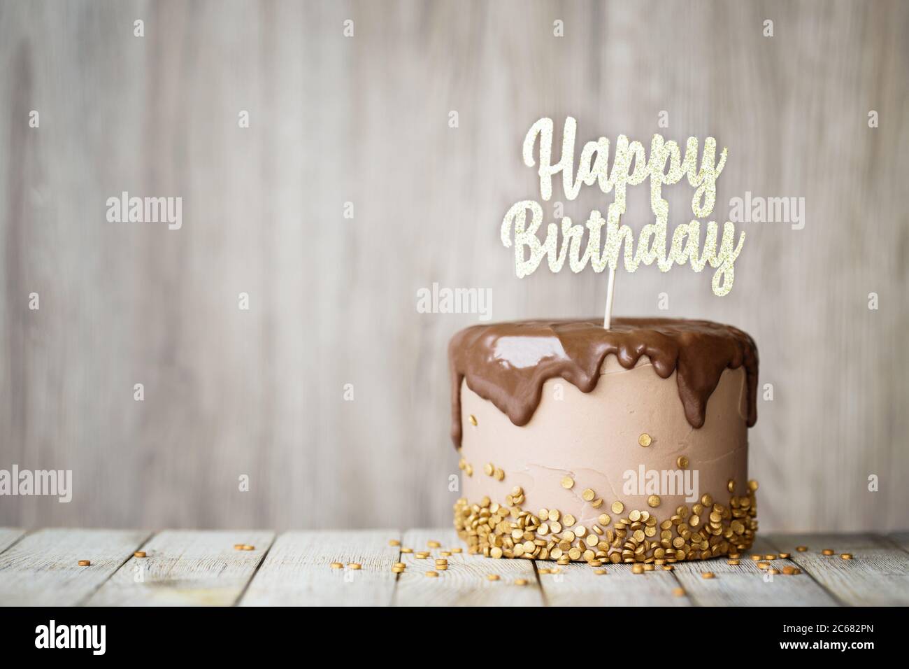 Geburtstagskuchen mit Schokolade Ganache und Geburtstagsbanner verziert Stockfoto