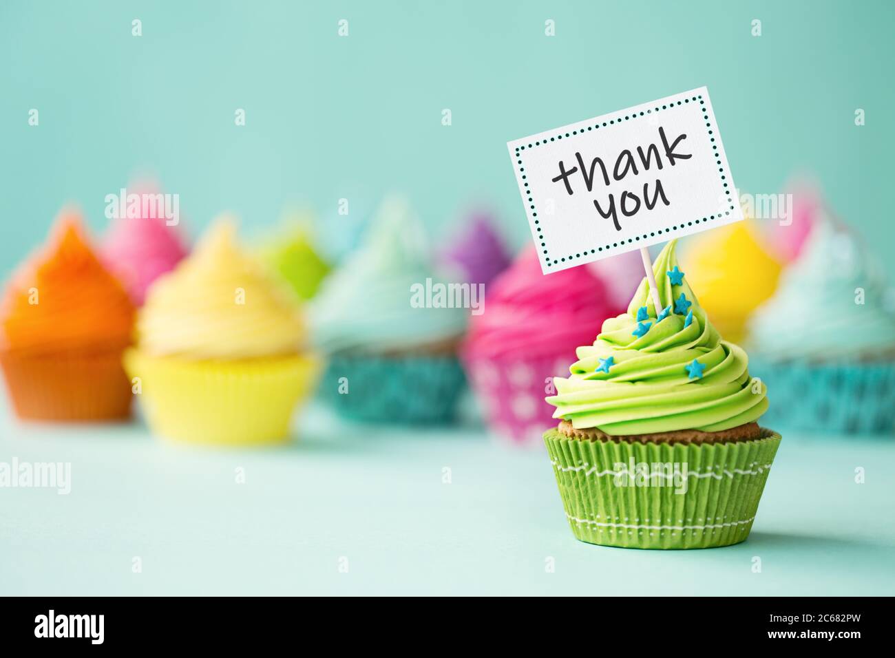 Sortiment an bunten Cupcakes mit Dankesschild Stockfoto