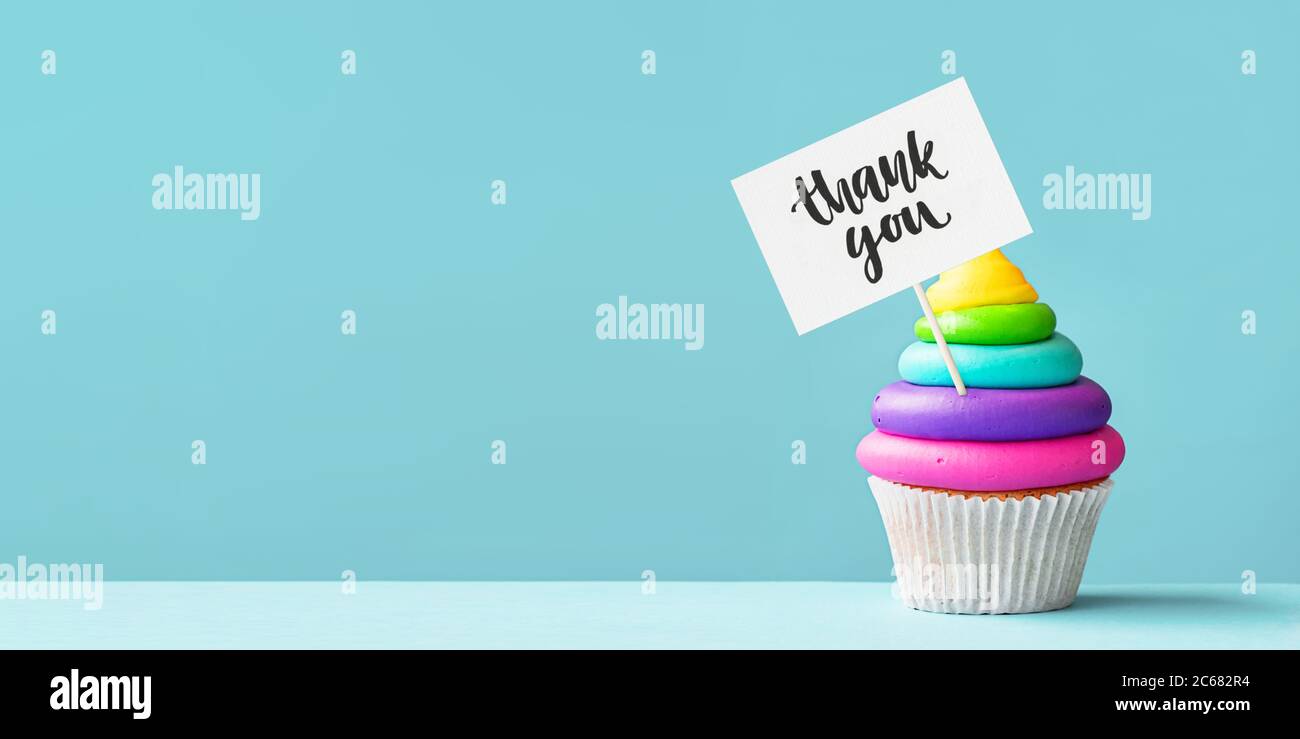 Bunt gefärbte Regenbogen Cupcake mit einem Dankeszeichen dekoriert Stockfoto