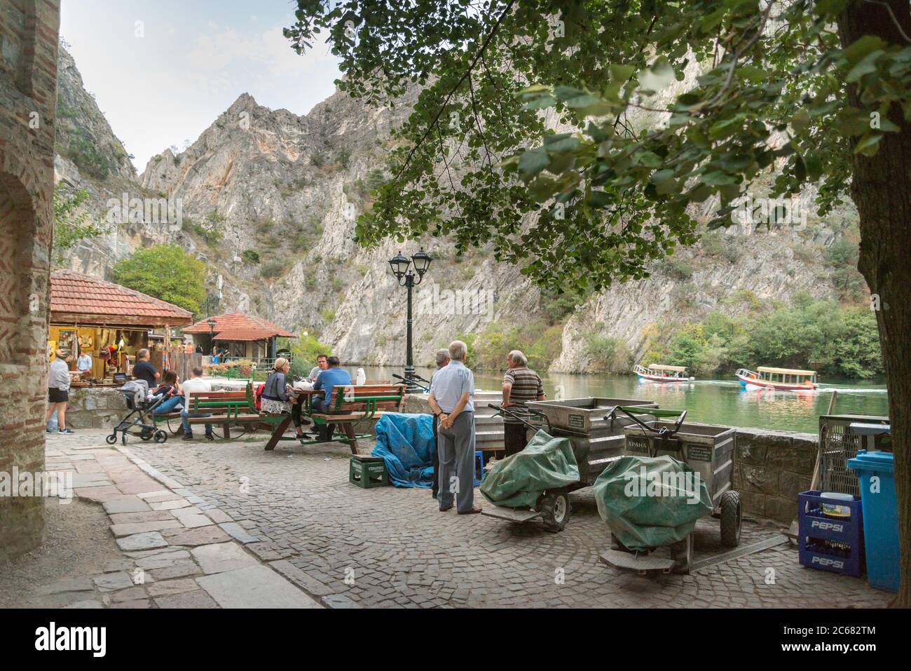 Am Matka Canyon, in der Nähe von Skopje, beginnen sich die Menschen am frühen Abend zu einem Essen oder Getränk neben dem ruhigen Wasser des Matka Sees zu versammeln. Stockfoto