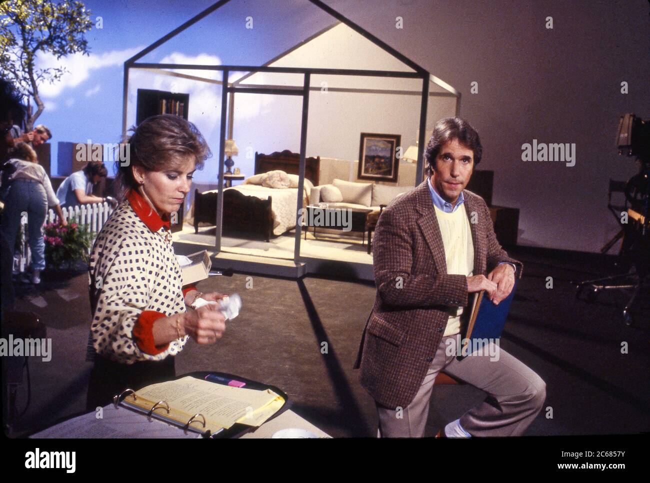 Schauspieler Henry Winkler geht mit einem Drehbuchleiter über seine Zeilen, bevor er einen Pormo-Spot für Comic Relief, um 1986, aufnahm Stockfoto