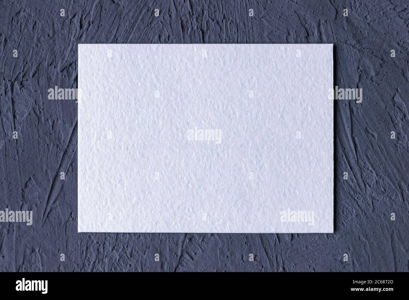 Weiße strukturierte Papierkarte auf dunkelgrauem einfarbigen Hintergrund Stockfoto