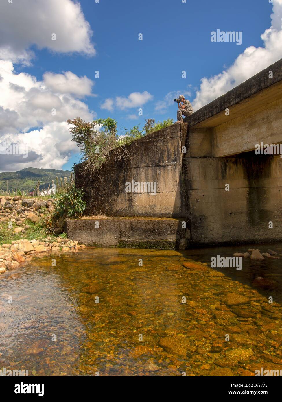 Ein Fotograf, der Vogelbilder vom Rand einer Del Valle-Flussbrücke im kolumbianischen Departement Santander einfängt Stockfoto