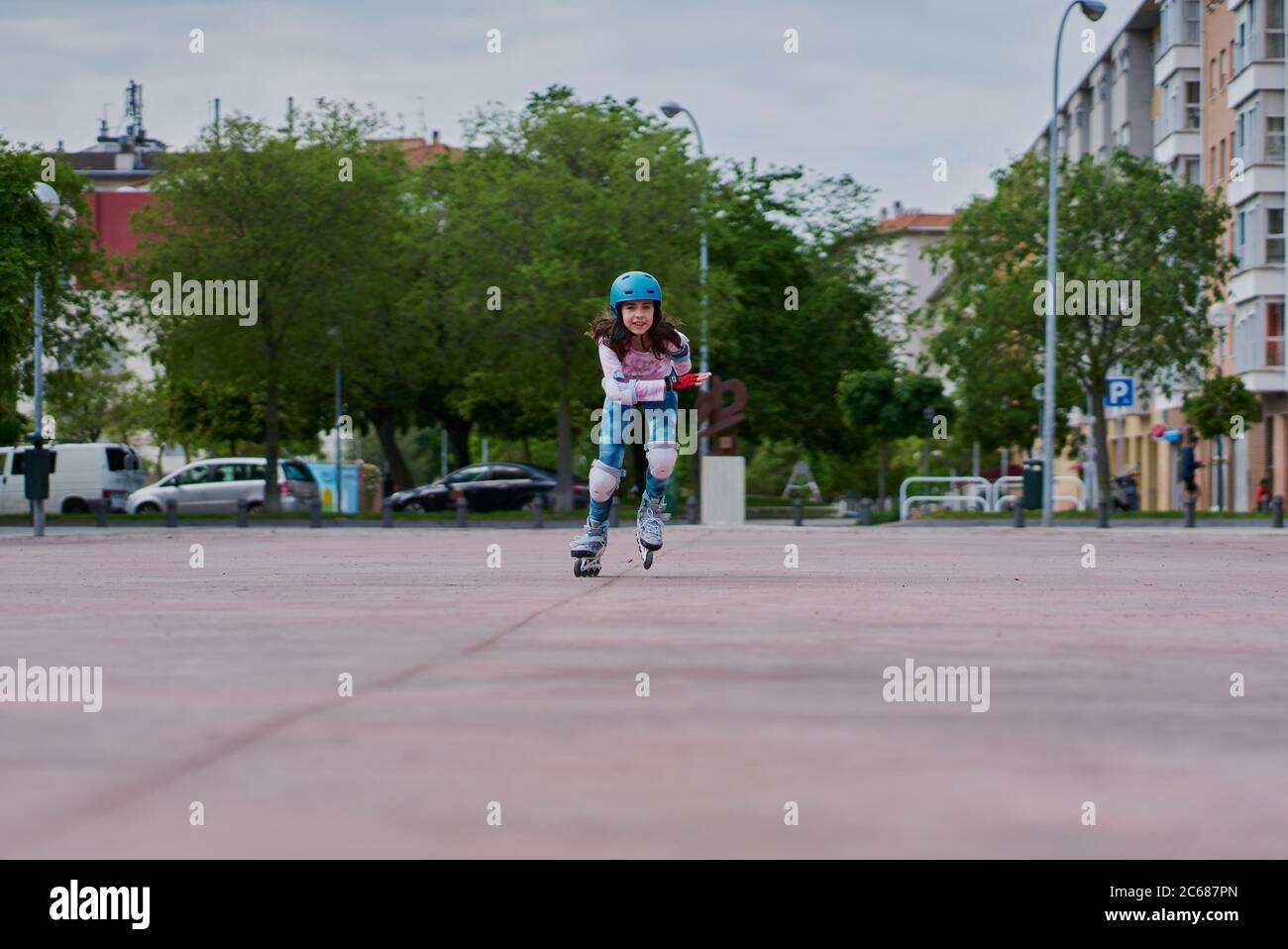 Mädchen auf der Straße Schlittschuhe mit Inline-Skates und Helm Stockfoto